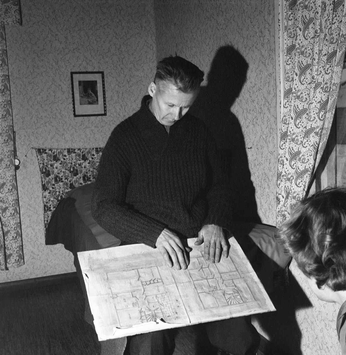 Johan Venninen tutkii talonsa rakennuspiirustuksia Hyvinkäällä 1959. Kuva UA Saarinen / JOKA / Museovirasto