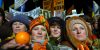 Neljä naista talvipäähineissä. Yhdellä on kädessään appelsiini. Taustalla näkyy mielenosoittajien kylttejä.. Kuvaaja: Hannu Lindroos / Journalistinen kuva-arkisto JOKA / Museovirasto. Objektinumero: SK10271_70