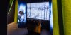 Muistin näyttelyttilaa, jossa valokuva sotilaasta lumipuvussa ja ruudulla kuvaa talvimaisemasta. Lattialla on teline, jossa on kuulokkeita.. Kuvaaja: Sodan ja rauhan keskus Muisti
